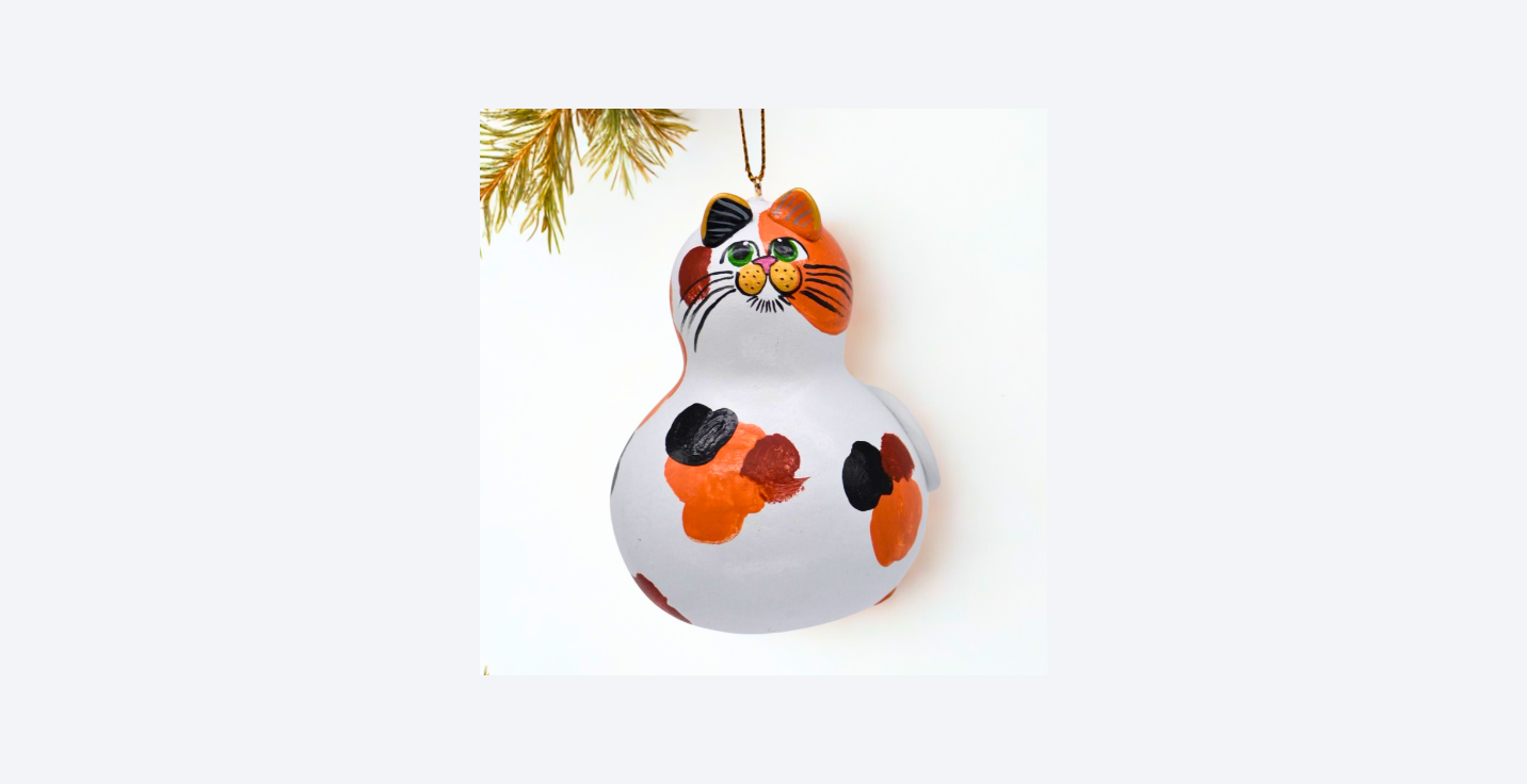Hand painted calico cat ornament on natural dried gourd with unique markings and lightweight design