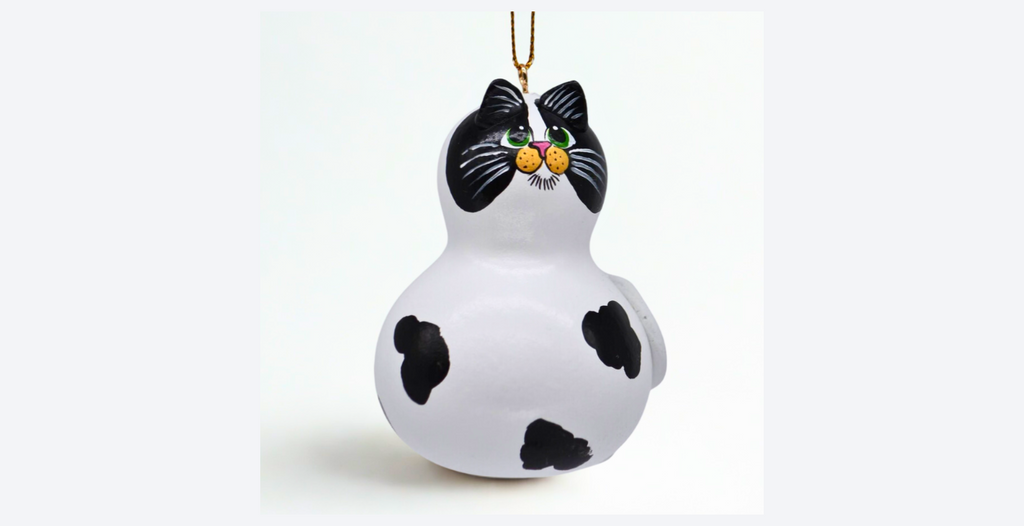 Hand painted cow cat ornament made from a natural mini bottle gourd with sculpted ears and tail, featuring unique black and white markings.