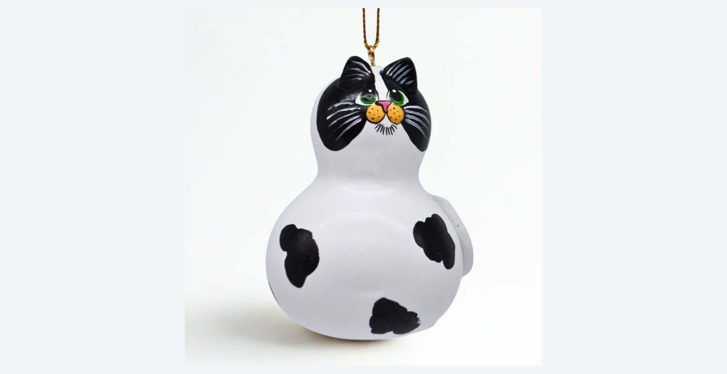 Hand painted cow cat ornament made from a natural mini bottle gourd with sculpted ears and tail, featuring unique black and white markings.