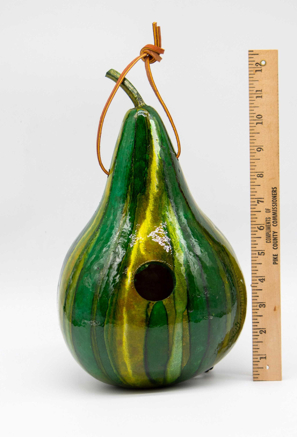 Handmade green striped gourd birdhouse with 1.5-inch entrance, designed for wrens and chickadees, featuring natural breathable material and pre-attached hanging loop.