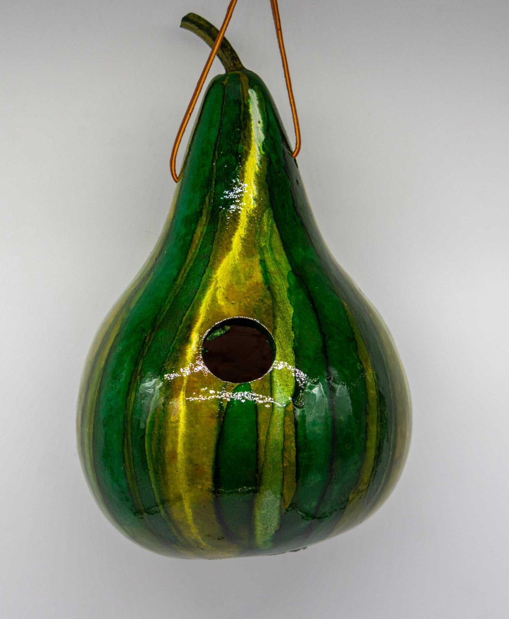 Handmade green striped gourd birdhouse with 1.5" entrance hole, ideal for wrens and chickadees, featuring natural breathable design and pre-attached hanging loop.