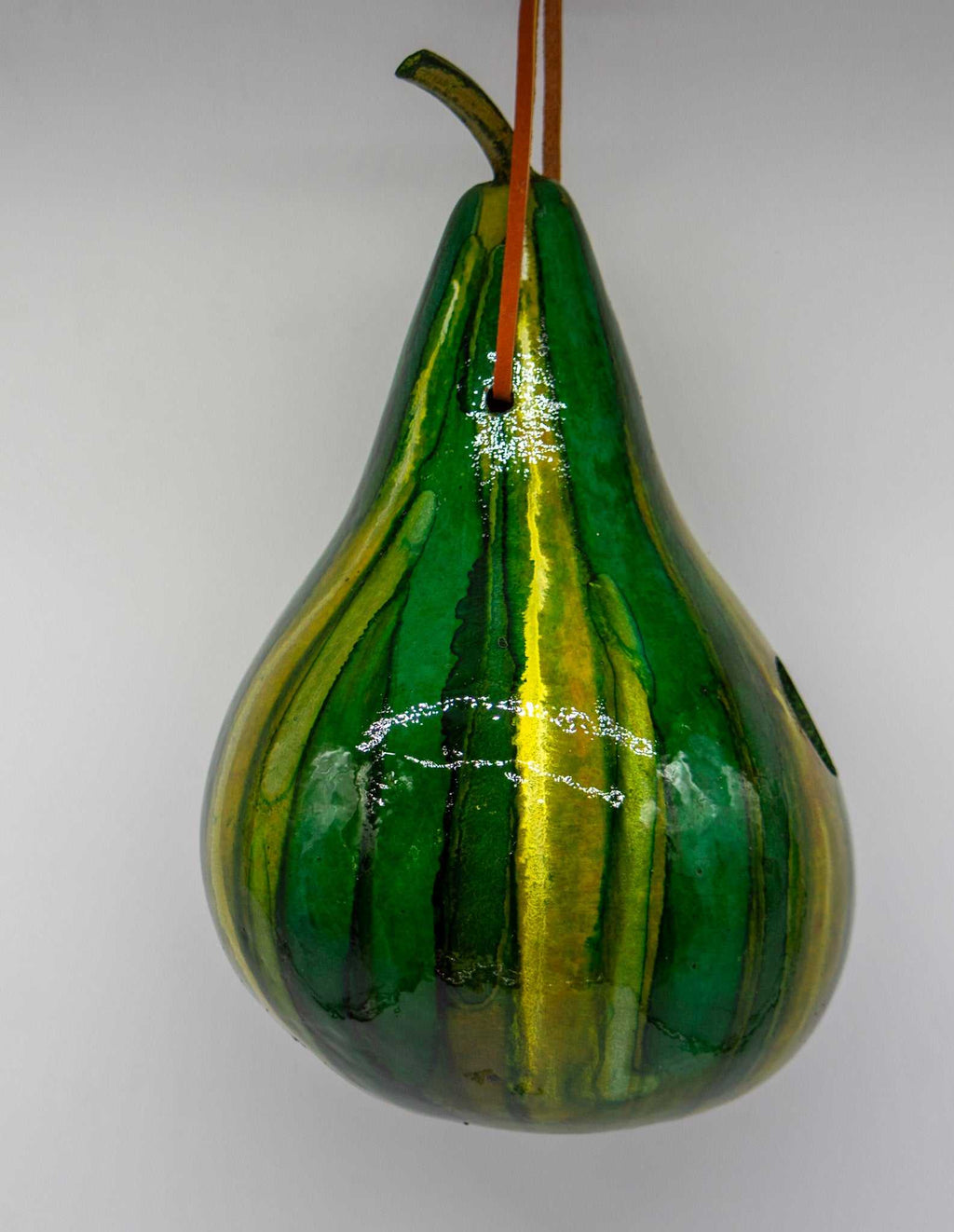Handmade green striped gourd birdhouse with 1.5-inch entrance hole, ideal for wrens and chickadees, featuring natural breathable material and hanging loop.