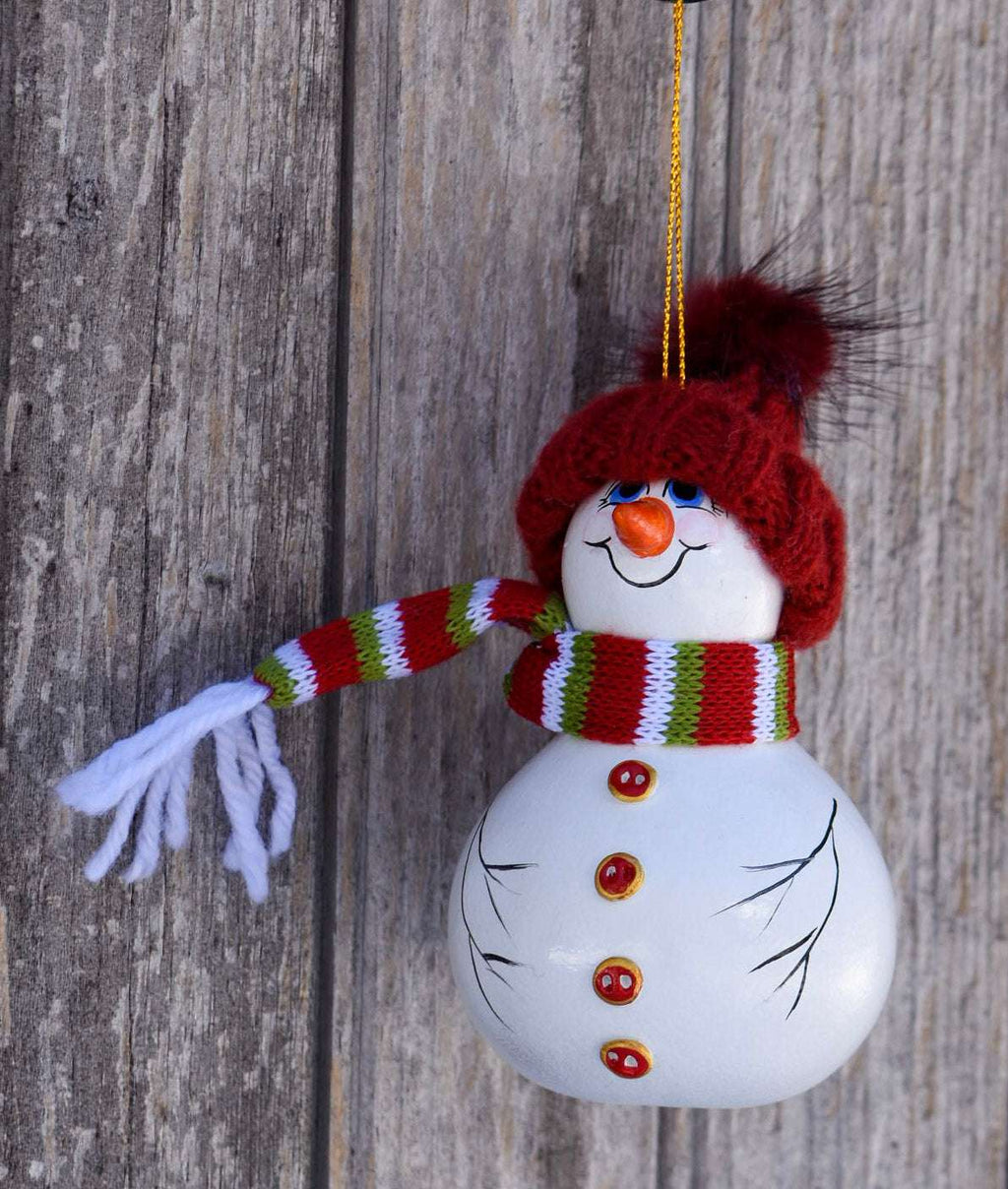 Hand painted snowman gourd ornament with red hat and festive scarf ready to hang on Christmas tree