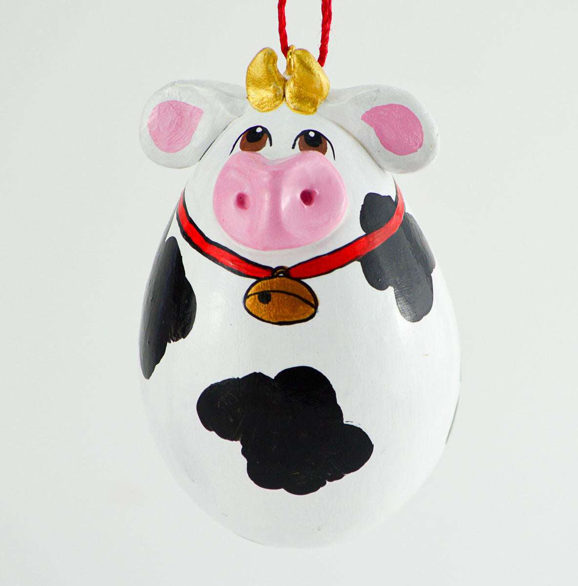 Painted egg gourd cow ornament with Holstein spots, gold cowbell, and red string hanging loop