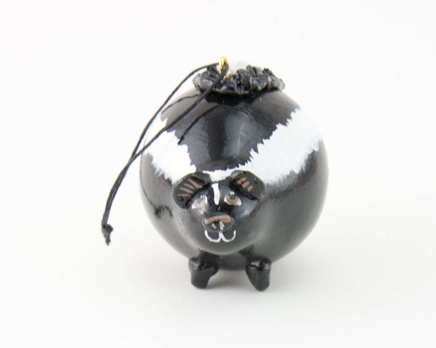 Handcrafted black and white skunk ornament made from dried gourd