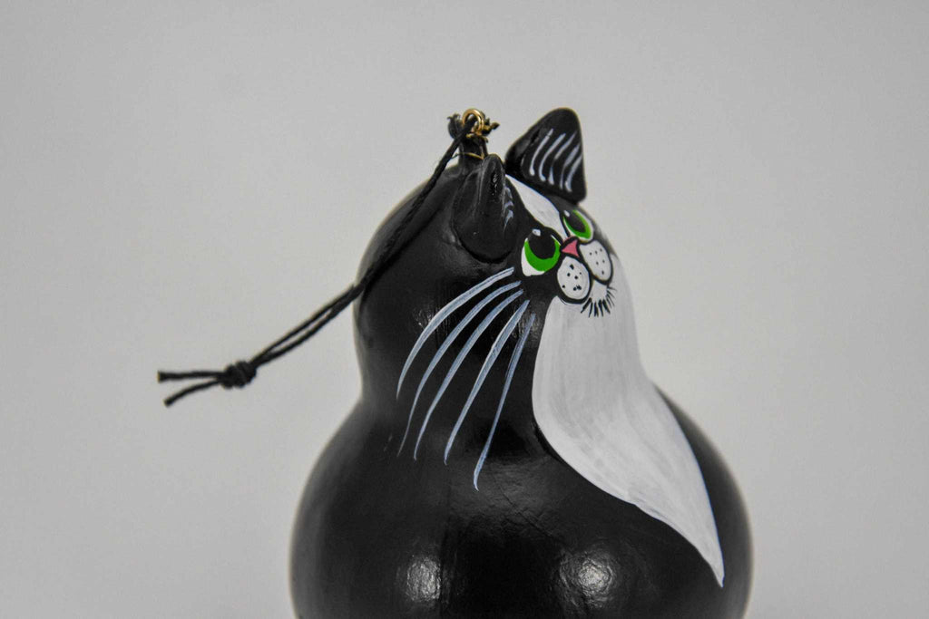 Handmade tuxedo cat ornament painted on dried gourd with green eyes and hanging string