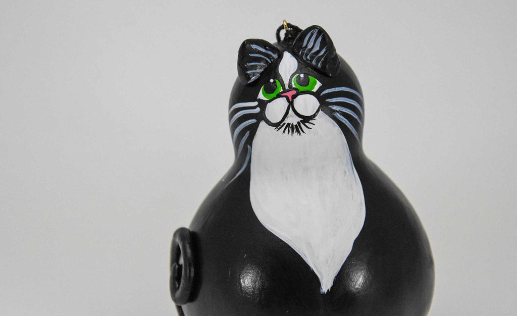 Hand-painted Tuxedo Cat Ornament made from dried gourd with green eyes and black and white tuxedo pattern, ready to hang.